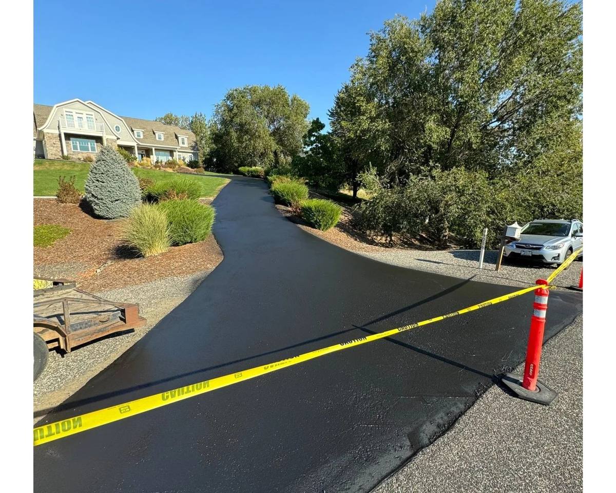 Freshly paved residential road with smooth new asphalt and a clean compacted edge
